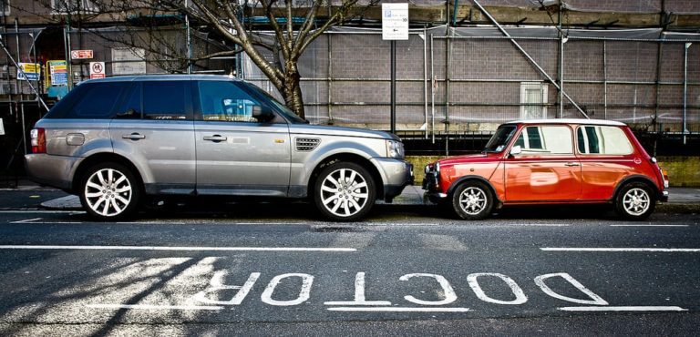 Large car on the left facing a small car on the right